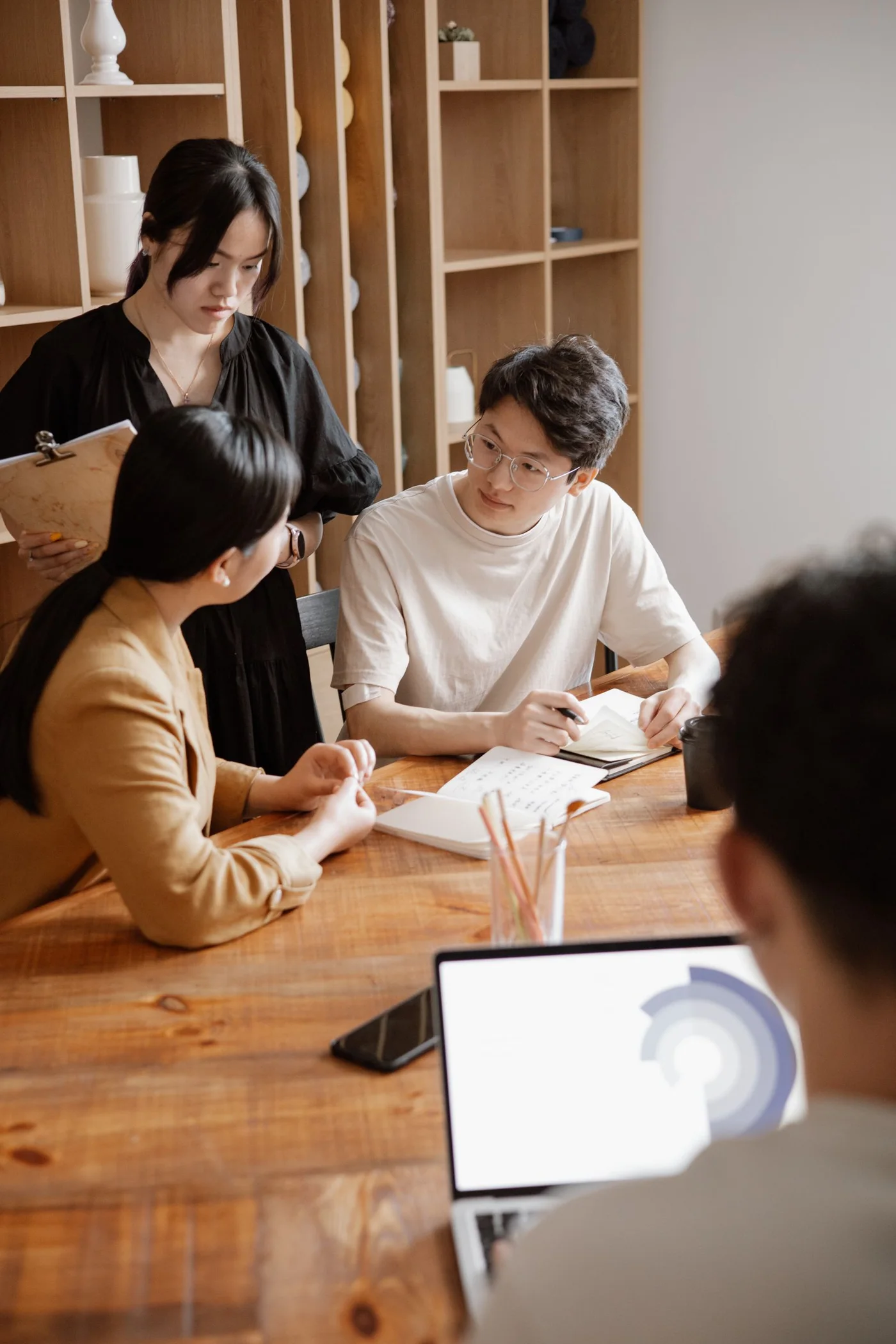 An editorial photograph of colleagues collaborating around a table